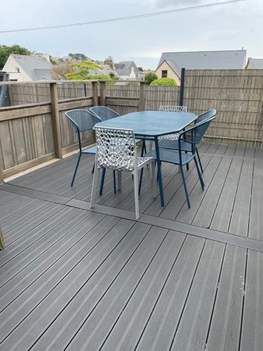 une table bleue et des chaises sur une terrasse dans l'établissement Maison de caractère Côte de Granit Rose, à Perros-Guirec