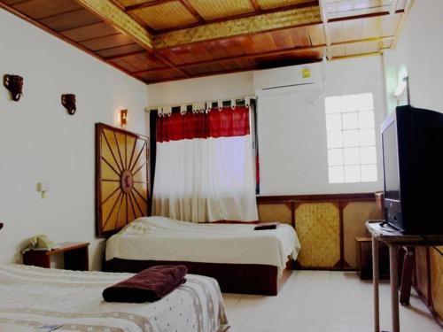 a hotel room with two beds and a television at Panorama Hotel in Mae Hong Son