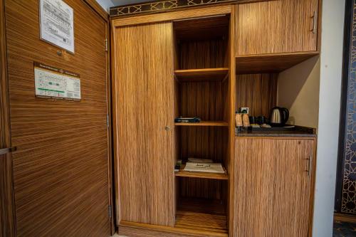 a room with a wooden closet with a door at Snood Al Marwa Hotel in Makkah