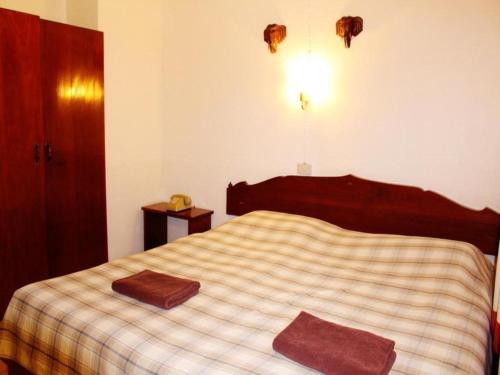 a bedroom with a bed with a checkered blanket at Panorama Hotel in Mae Hong Son