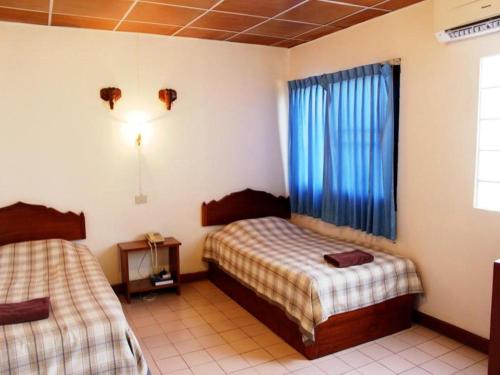 a bedroom with two beds and a window at Panorama Hotel in Mae Hong Son