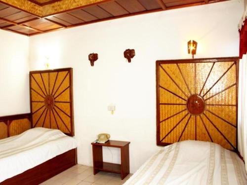 a bedroom with two beds and a window at Panorama Hotel in Mae Hong Son