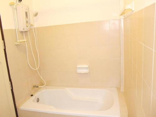 a white bath tub in a tiled bathroom at Panorama Hotel in Mae Hong Son