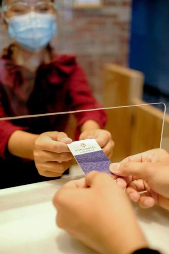 a person is getting their nails polished with a tag at Fitra Hotel Majalengka in Majalengka