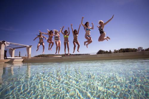a group of women jumping into a swimming pool at Bastide Saint Maurin in Ansouis