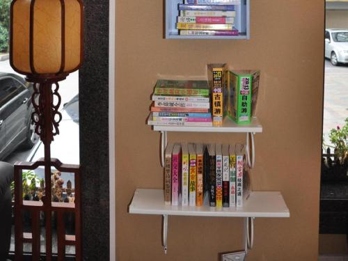 a book shelf filled with books next to a lamp at Oriental Hotel in Dongguan