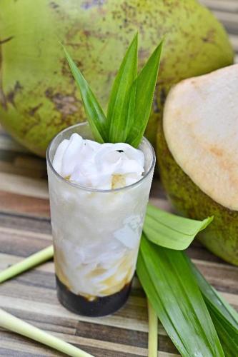 a glass of ice cream and some green leaves at Lotus Hotel Subang in Bandung