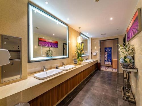 a bathroom with two sinks and a large mirror at Lavande Hotel Tianjin Youyi Road Xiaobailou 5th Avnue in Tianjin