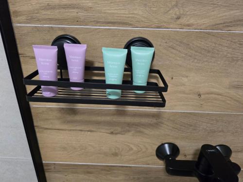a shelf with four different colored cups on it at Apartman FIŠBAH 4 self CHECK-IN, FREE PRIVATE PARKING in Osijek