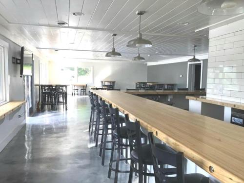 a long bar in a room with chairs and tables at Keuka Lake Motel - Adults Only in Dundee
