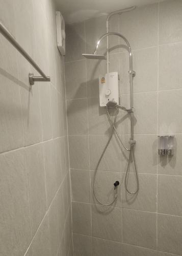 a shower with a shower head in a bathroom at Neighbor Hostel in Haad Rin