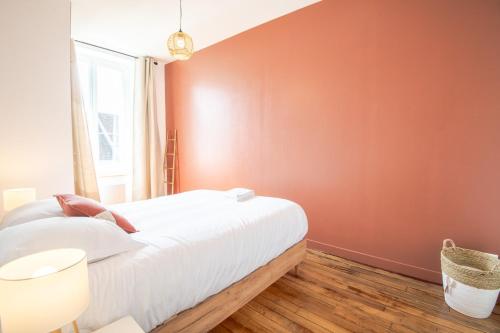une chambre avec un lit et un mur rouge dans l'établissement LE FRANCUEILLOIS - T3 NEUF, à Francueil