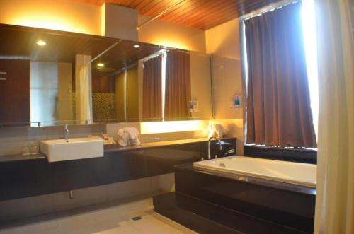 a bathroom with two sinks and a large mirror at Ratu Hotel Serang in Serang