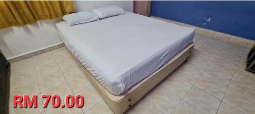 a bed sitting on a tiled floor in a room at An najmie roomstay paka in Paka