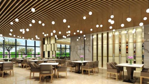 a restaurant with tables and chairs and lights at Fliport Garden Hotel Nanjing in Nanjing