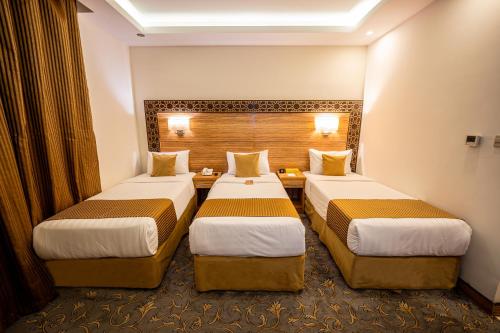 a hotel room with two beds in it at Snood Al Marwa Hotel in Makkah