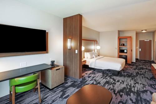 a hotel room with a bed and a flat screen tv at Fairfield Inn & Suites by Marriott Liberal in Liberal