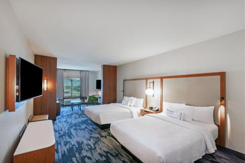 a hotel room with two beds and a flat screen tv at Fairfield Inn & Suites by Marriott Liberal in Liberal