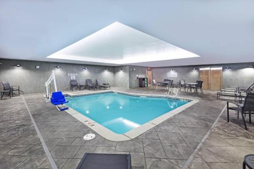 a pool in a room with chairs and tables at Fairfield Inn & Suites by Marriott Liberal in Liberal