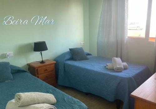 une chambre avec deux lits et un panneau indiquant baraja mate dans l'établissement BeiraMar La Caleta, piscina y wifi gratis, tranquilidad junto al atlántico, à Parque Holandes