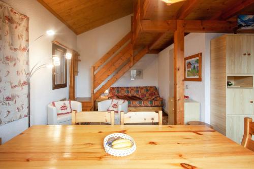 une salle à manger avec une table et des chaises en bois dans l'établissement Appartement confortable à Megève - 60 m² - vue sur montagnes, à Megève