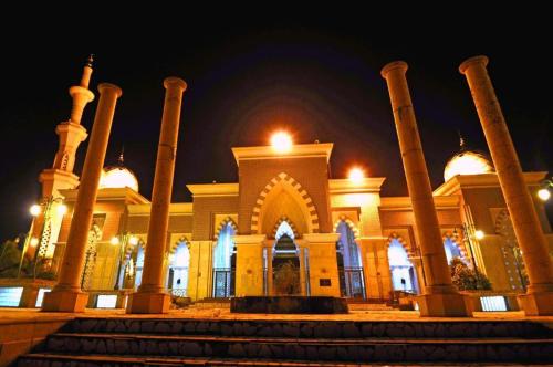 a large building with columns and lights at night at Kenari Tower Hotel in Makassar