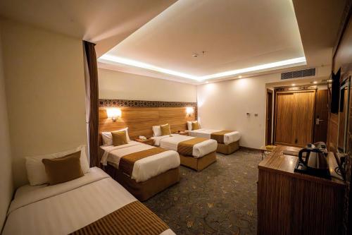 a hotel room with two beds and a television at Snood Al Marwa Hotel in Makkah