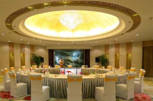 a conference room with tables and chairs and a chandelier at Huangshan International Hotel in Huangshan