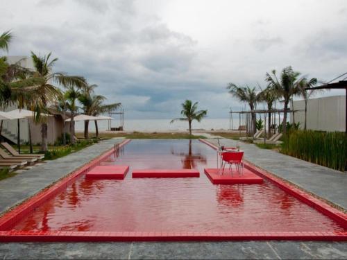 a pool of red water with red chairs in it at Red Z The Ocean in Phetchaburi