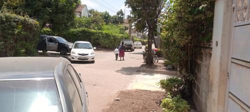 a street with cars parked on the side of the road at L'auberge Homestay in Nairobi