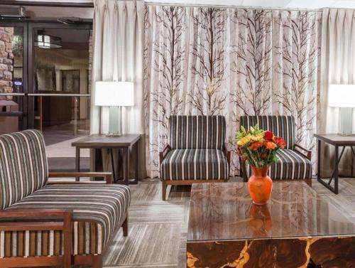 a lobby with two chairs and a vase of flowers on a table at Days Inn Springfield South in Springfield