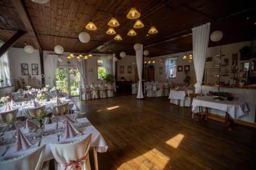 a banquet hall with white tables and chairs at Wegeners Landhaus UG in Uelzen