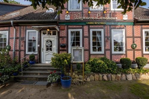 a brick building with a sign in front of it at Wegeners Landhaus UG in Uelzen