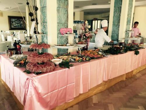 a buffet line with food on a pink table at Hotel Lady Mary in Milano Marittima