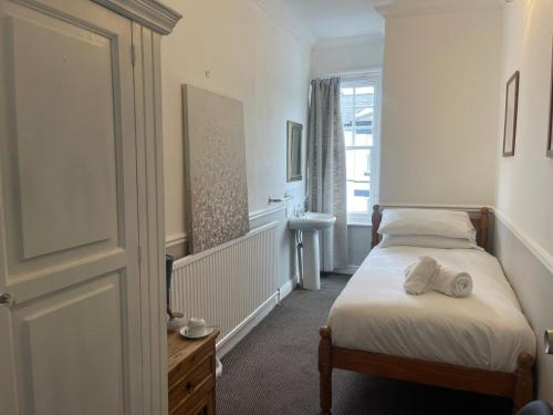 a small bedroom with a bed and a window at Central Hotel in Norwich