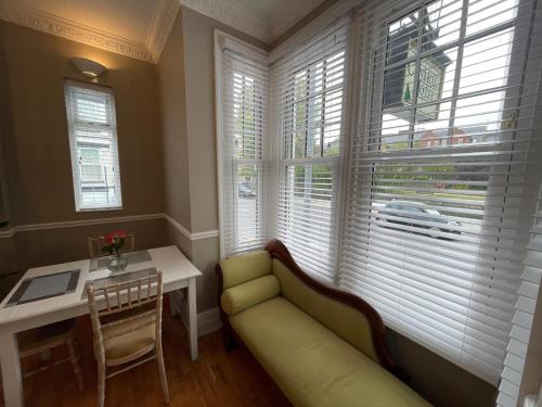 a living room with a couch and a table and windows at Central Hotel in Norwich