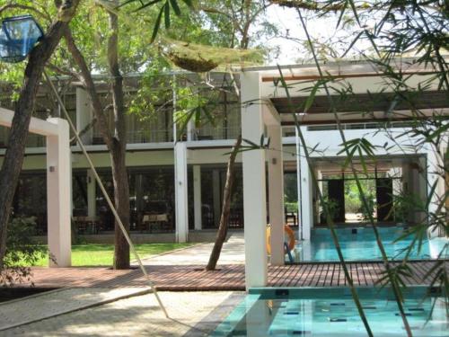 a house with a swimming pool and trees at Neem Villas in Tanjanagaram