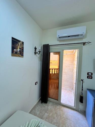 a room with a sliding glass door with a window at Reef House in Marsa Alam City