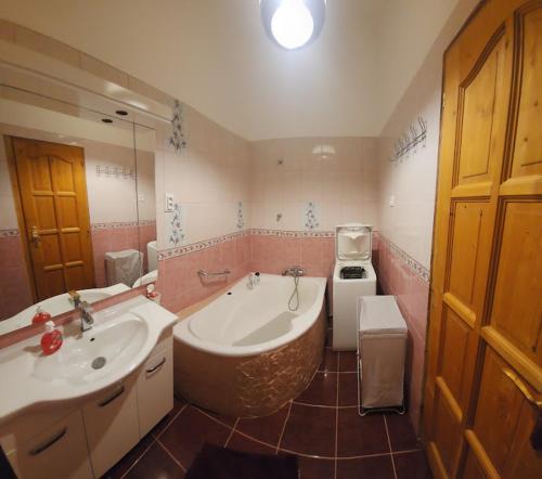 a bathroom with a tub and a sink and a stove at Rom Apartman in Budapest