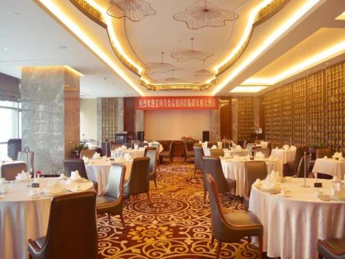 a dining room with tables and chairs with white table cloth at Xian Jue Vu Hotel in Xi'an
