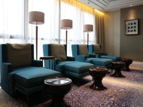 a waiting room with blue chairs and tables and windows at Xian Jue Vu Hotel in Xi'an