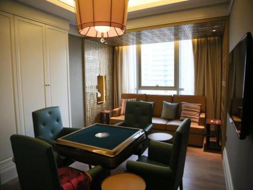 a living room with a couch and a table and chairs at Xian Jue Vu Hotel in Xi'an