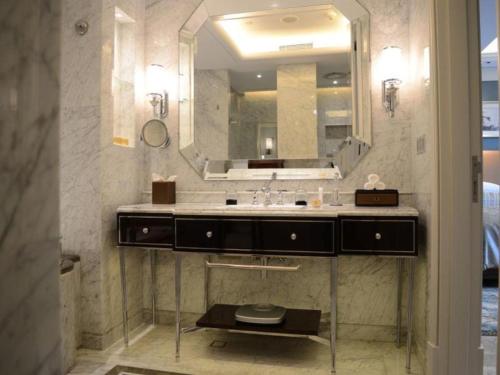 a bathroom with a sink and a large mirror at Xian Jue Vu Hotel in Xi'an