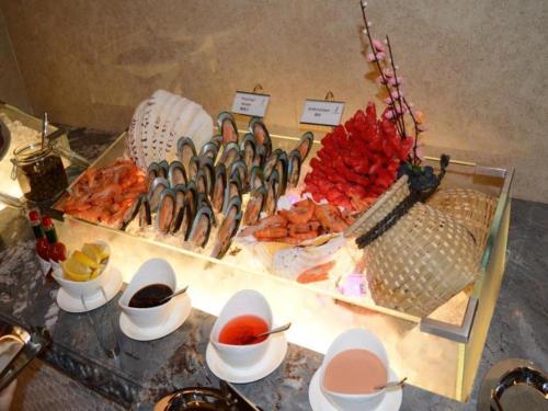 a buffet of food on a table with bowls and plates at Xian Jue Vu Hotel in Xi'an