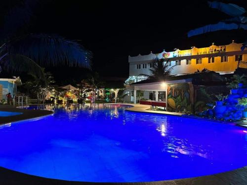 a large swimming pool at night with blue lights at Coco Mango's Place in Panglao