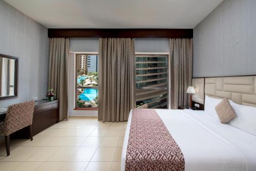 a hotel room with a large bed and a window at Suha JBR in Dubai