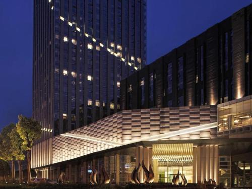 a large building with a lit up facade at night at Chongqing The Lotus Hotel in Chongqing