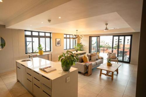 a kitchen and living room with a couch and a table at Ocean Family Deluxe, Hermanus Waterfront - Apt 2 in Hermanus
