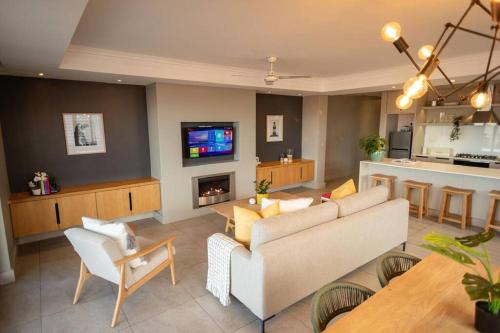a living room with a couch and a tv at Ocean Family Deluxe, Hermanus Waterfront - Apt 2 in Hermanus