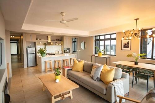 a living room with a couch and a kitchen at Ocean Family Deluxe, Hermanus Waterfront - Apt 2 in Hermanus